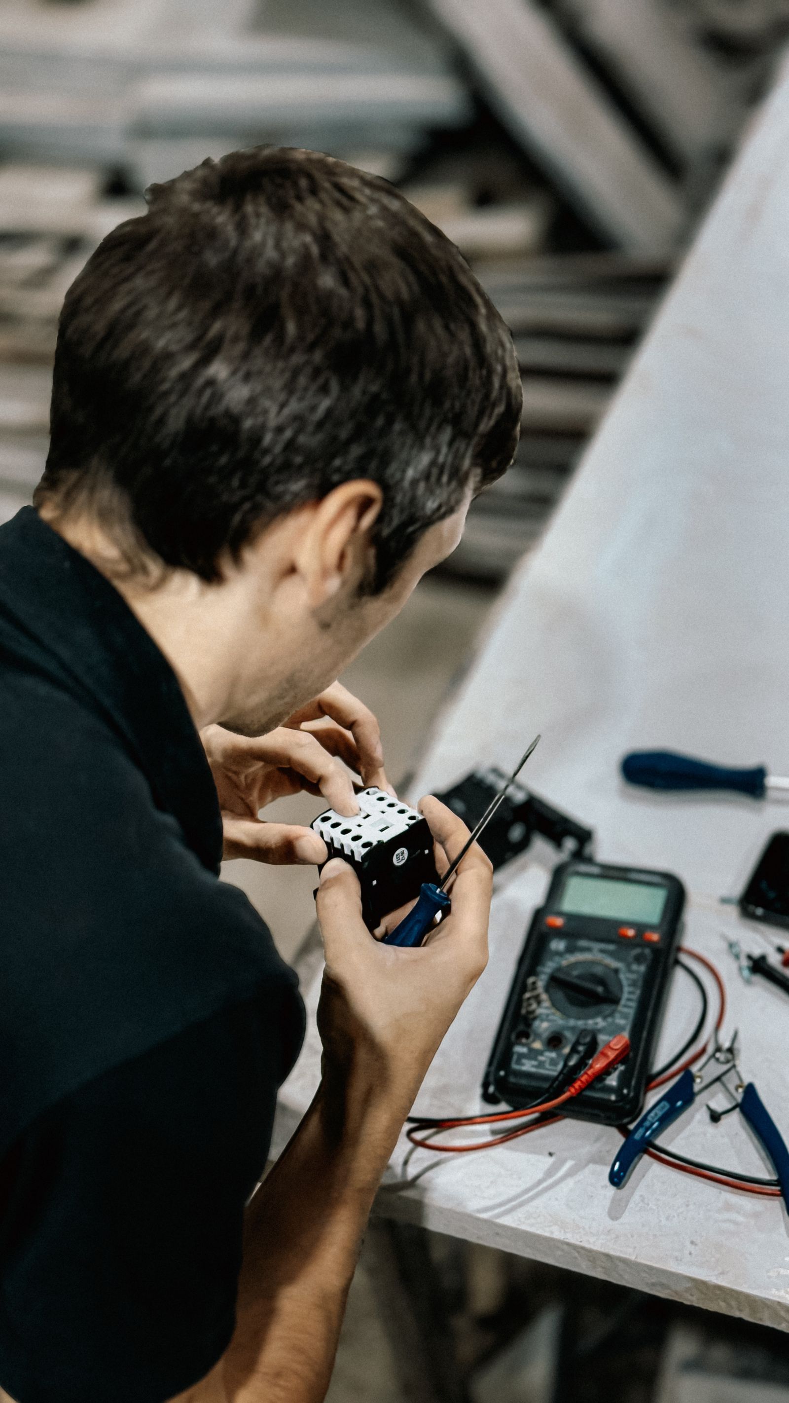 Technician repairing electrical components at a workbench
